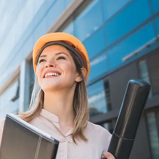 joven arquitecta sonrie orgullosa con cacrpeta negra y estuche de planos